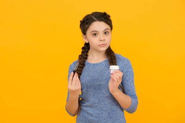 Happy child girl has fashionable hairstyle using natural cosmetics powder on yellow background, beauty blog — Stock Photo, Image