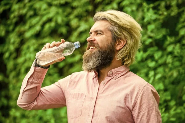 Uppfriskande lemonad. Läskvatten. Vattenbalans. Man skäggig turist dricksvatten plastflaska natur bakgrund. Sommarvärme. Törstig kille som dricker vatten på flaska. En hälsosam livsstil. Varm dag — Stockfoto