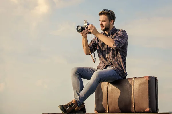 Reiseblog. Mann sitzt auf Koffer. Schöner Kerl Retro-Kamera. Mann im Freien mit Vintage-Koffer. Fotoreporter. Reisen mit Gepäck. Reiseblogger. Schießen vlog. Urlaubszeit — Stockfoto