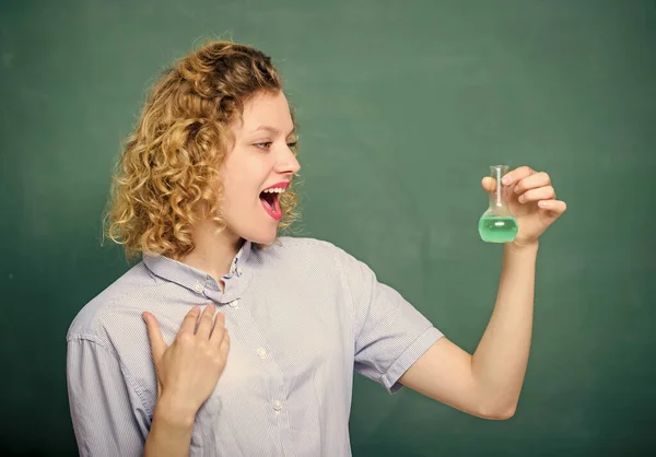 Scheikundeles. Chemie lab. Interessant en fascinerend. Verken chemie. Meisje observeert chemische reactie krijtbord achtergrond. Vrouwelijke leraar die experimenteert met gloeilamp en vloeistof — Stockfoto