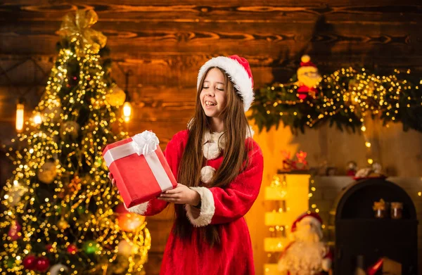Der Weihnachtsmann brachte Geschenke. Zeit für Wunder. Alles, was ich mir für Weihnachten wünsche. Glück und Freude. Kind glücklich aufgeregt Mädchen finden Geschenke in der Nähe von Weihnachtsbaum. Frohe Weihnachten. Glückliche Kindheit. Weihnachtsmütze für Kinder — Stockfoto
