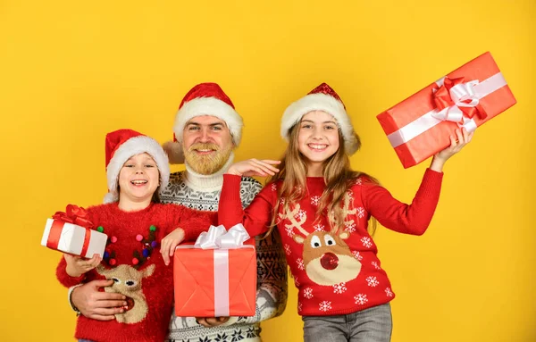 Feliz Navidad. compras de año nuevo. Es hora de regalos. familia feliz celebrar la Navidad. Las niñas pequeñas intercambian regalos con el padre. Papá ama a las hijas. Papá Noel barbudo con niños. moda de punto para el invierno —  Fotos de Stock