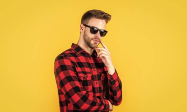 Tasarım mükemmel. Gözlüklü seksi kıllı sakallı adam. Yüz kılları ve cilt bakımı. Yakışıklı adam kareli gömlek giyiyor. Tıraşsız, sıradan bir adam. Kuaför ve berber dükkanı. Erkek güzellik eğilimi