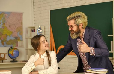 Küçük kız ve adam tahtaya karşı. Bilgi toplama günü. Sınıfta öğretmeni olan bir çocuk. Öğretmenler günü konsepti. Danışman öğrenci. Evde eğitim projesi. Liseli kız özel öğretmeniyle ders çalışıyor.