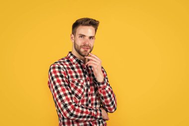 Sonbahar tarzı. Kendine güvenen ve sakin. Sakallı ve kıllı yakışıklı sıradan bir adam. Neşeli ve şık. Kırmızı arka planda yakışıklı bir adam. Seksi Avrupalı iş adamının kapalı mekan portresi. Boşluğu kopyala