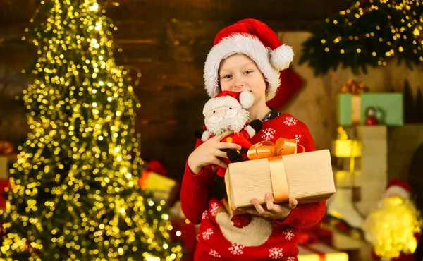 サンタは贈り物をくれた。12月の伝統。割引販売。本当に幸せ。クリスマスツリーの近くに子供の幸せ興奮。メリークリスマス。幸せな子供時代のコンセプト。子供はサンタの帽子とクリスマスセーターを着て — ストック写真