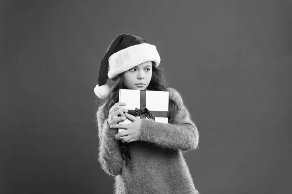 Sólo la mía. ventas de compras de niños. día de boxeo de Navidad. mejor oferta de Navidad. Niña sostiene la caja de regalo. feliz año nuevo regalo. Fiesta navideña. Niña con sombrero de santa. codicioso niño rojo pared. —  Fotos de Stock