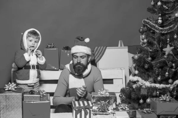 Christmas family opens presents on dark red background — Stock Photo, Image