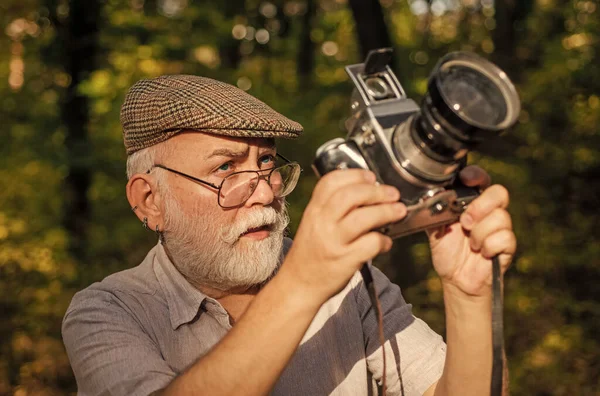 Pasatiempo de pensiones. Fotógrafo experimentado. Cámara vintage. El viejo dispara a la naturaleza. Fotógrafo profesional. Haz un marco perfecto. Paisaje naturaleza foto. Un viejo fotógrafo filmando. Configuración manual — Foto de Stock