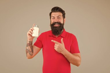 Yan etkiler. İlaç konsepti. Erkek sağlığı için gıda katkı maddeleri. Vitamin kompleksi. Yakışıklı sakallı adam ilaç alıyor. Sağlık hizmetleri. Hippi plastik kap tutar. Sağlık yatırımları
