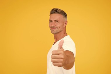 Bu ürünü tavsiye ederim. Mutlu adam baş parmağını kaldırdı. Yakışıklı adam reklam ürünleri. Ürünü sunuyorum. Ürün tanıtımı. Satış ve pazarlama. En iyi avantajları sunan, kopyalama alanı