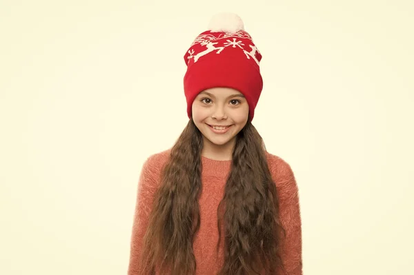 Уютный зимний наряд. Малыш носит вязаную шляпу. Оставайтесь в тепле этой зимой. Счастливая маленькая девочка зимний модный аксессуар. Маленький ребенок улыбается в меховой шляпе белый фон. Симпатичная модель наслаждается зимним стилем — стоковое фото