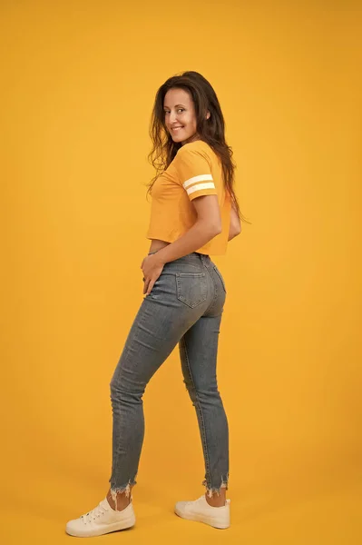 Los vaqueros pitillo le quedan bien. La confianza en uno mismo es el mejor equipo. Sexy chica de fondo amarillo. Chica Sexi. Chica sensual en estilo casual. Una chica bonita con el pelo largo. Moda y estilo. Belleza y maquillaje — Foto de Stock