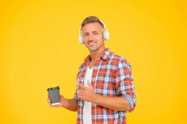 Njut av en kopp av detta för att börja dagen. Glad man pekar finger åt kaffemuggen. Morgonvanor. Musikkul. Modern livsstil. Tillfällig stil. Du kommer att vara igång hela morgonen. — Stockfoto