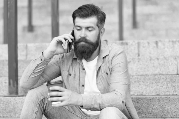 Vida móvil. Hipster beber café hablando en el teléfono móvil al aire libre. Comunicación móvil. Una taza caliente. Café para llevar. Nueva tecnología. Dispositivo móvil. 4G. 3G. Estilo de vida moderno — Foto de Stock