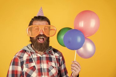 Güzel renk. Parti gözlüklü adam balon tutuyor. Bayram kutlaması. Doğum günün kutlu olsun. Şirket partisi kutlaması. Merhaba yaz. Yaz tatili partisi. Mutluluğu hisset. Sakallı mutlu adam.