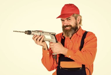 Duvarı delmek için taş ustası olmak lazım. Beyaz arka planı delinmiş şapkalı bir adam. Perforatör ve ısırık. Güçlü matkap. Matkap al. Tamirci delik açıyor. Güvenlik önlemleri. Sondaj konsepti