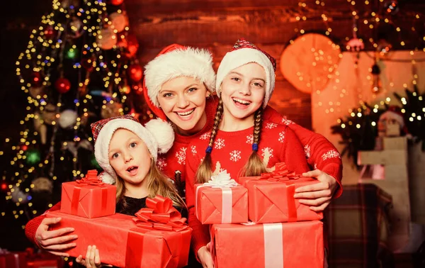 Concepto familiar feliz. Maravillosos momentos de Navidad. Lograr impecable día de Navidad. Niñas con muchas cajas de regalo. La rutina de la mañana de Navidad para las madres. Mamá abrazo hijas cerca de árbol de Navidad —  Fotos de Stock