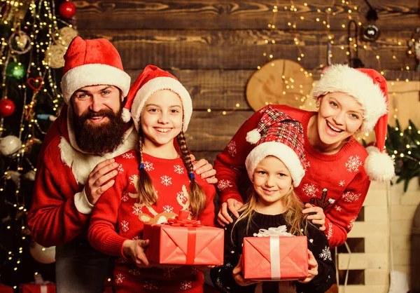 Šťastná rodina slaví Nový rok a Vánoce. Santa otec na zdobeném stromě. Veselá matka miluje děti. Sestřičky s rodiči. Dárek od Santy. Okamžiky výběru nejlepšího dárku. — Stock fotografie