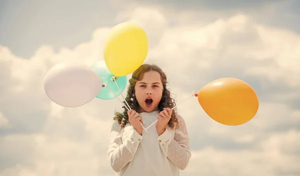 Journée internationale de l'enfance. Enfant heureux avec des ballons à air coloré sur fond de ciel bleu. exprimer des émotions positives. Amuse-toi bien. la liberté. vacances d'été célébration — Photo