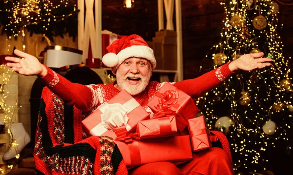 Викупляють подарунки. Зимові канікули. Санта Клаус відпочиває в кріслі на руці. Традиційна концепція. Санта Клаус біля дерева христмас. Обожнений старший брат Санта Клаус. Веселих кристалів. Літній дідусь удома. — стокове фото