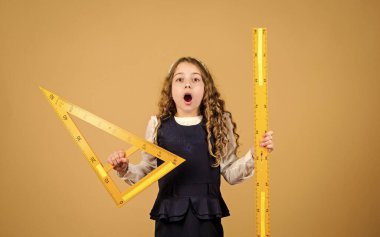 Geometri dersi. Eğitim ve okul konsepti. Zekice ve zekice bir fikir. Boyut ve boyut. Büyük cetveli olan tatlı bir öğrenci. Öğrenci geometri okuyor. Çocuk okulu üniforması. Cetvel.