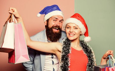 Hediyeleri önceden hazırla. Mutlu noeller. Erkek ve kadın alışverişi. Noel alışverişi. Neşeli Noel Baba şapkaları kağıt torbalar taşır. Hediyeler al. Mutlu yıllar. Aile alışverişi. Kutlamaya katıl