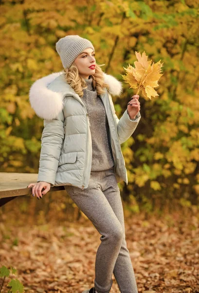 Kleding voor de rust. Vrouw genieten van de herfst seizoen in het park. Warme gebreide kleding. Meisje ontspannen in de natuur dragen van gebreide kleding pak en jas. Model breigoed kleding bladeren achtergrond. Voel je praktisch en comfortabel — Stockfoto