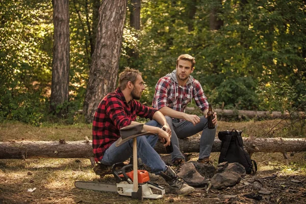 ハイキングと人。2人の男が森の中でリラックス。ハイキングとキャンプ。男性の友情。親友のビールを飲んでる。野外活動でレンジャー。ピクニックの週末を自然の中で過ごす。観光コンセプト — ストック写真