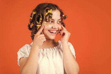 Çocuklar için saç stili yapmak için kolay ipuçları. Kuaför aletleri ve saç aksesuarları. Yüzü yamalı çocuk. Saç bigudileriyle poz ver. Kuaförde oynayan, saç bigudili mutlu kız. Boşluğu kopyala