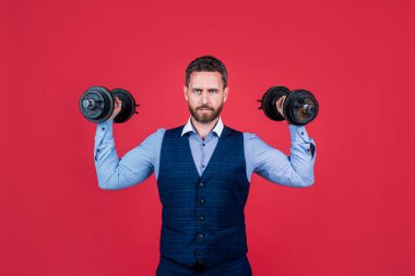 Sıkı çalış. Güçlü çalışan halterler, kırmızı arka plan. İnşaat işi. Kariyer eğitimi. Meydan okuma ve dayanıklılık. Fiziksel güç. Güçlü ol.