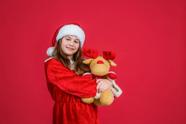 Felice Natale bambina ragazza indossare cappello rosso Babbo Natale e giocare costume con giocattolo renna, negozio di giocattoli — Foto Stock