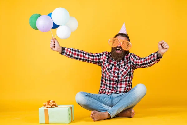 Eğlence ve mutluluk konsepti. Mutlu adam renkli helyum balonları tutuyor. hipster mutlu bir şekilde gülümsüyor. Partide eğleniyorum. Tatil için hazırlanın. Etkinlik yöneticisi şenlikli aksesuarlarla poz veriyor — Stok fotoğraf