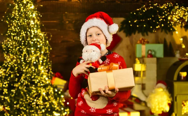 Verdadera felicidad. Niño feliz emocionado cerca del árbol de Navidad. Feliz navidad. Concepto de infancia feliz. Los niños usan sombrero de santa y suéter de navidad. Papá Noel me trajo regalos. Tradición de diciembre. Descuento venta — Foto de Stock