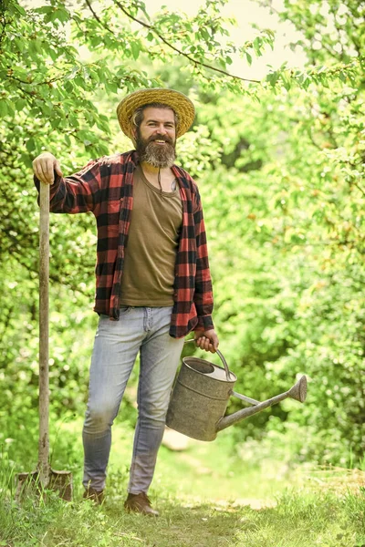 Jardinagem em horta. rega de plantas e flores. Jardineiro cavando com pá. trabalhador agrícola maduro com pá e regador. agricultor masculino caucasiano no país — Fotografia de Stock