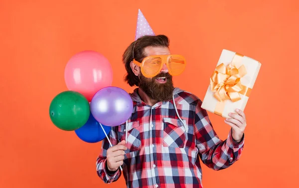 Volwassen knappe man in geruite shirt met feest ballonnen en huidige doos, winkelen — Stockfoto