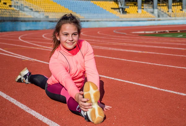 Flexibilidad dividida. entrenamiento de niños en la escuela lección física. adolescente estiramiento antes de entrenar. gimnasta prepararse para la competencia. atleta calentándose en el gimnasio del estadio. Ejercicios de estiramiento — Foto de Stock