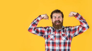 Güç dolu. Tıraşsız suratında bıyığı olan sakallı bir adam. moda ve güzellik. Berber dükkanı konsepti. Erkekler giyer. Kareli tişörtlü, olgun, mutlu bir adam. şık erkek günlük kıyafetler giyer.