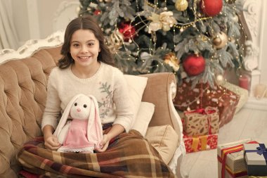 Yılın en iyi zamanı. Sevimli kız Noel arifesinde oyuncakla oynuyor. Samimi bir konsept. Gülümseyen çocuk kış tatilinin tadını çıkarıyor. Kış tatili Kış süslemeleri. Büyüleyici bir atmosfer. Kış harikalar diyarı
