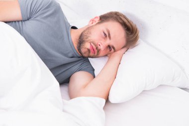 Yatakta bir dakika daha. Uykulu adam sabah uyandığında yatakta uzanıyor. Yorgun adam yatakta uyuyor. Benim için yatak.