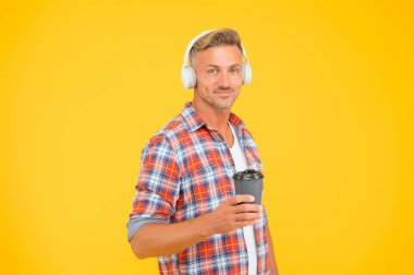 Son damlasına kadar iyi. Mutlu adam kahve fincanını sarı arka planda tutuyor. - Evet. Paket servis içkisi. Sıcak içecek. Kahve molası. Modern teknoloji. Müzik ve eğlence. Sabah alışkanlığı. Canının istediği zaman.