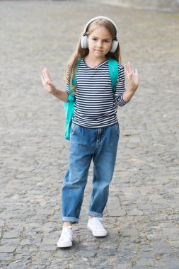 Macera benim en iyi terapim. Dışarıda sırt çantası taşıyan sevimli bir çocuk kulaklık takıyor. Müzik dinliyor. Modern teknoloji. Seyahat ve macera. Seyahat şarkısını tekrar tekrar çal