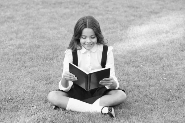 Glad förskoletjej med bok på skolgården. Tillbaka till skolan. hårt arbetande barn med bok. begreppet utbildning och läsning. utveckling av fantasin. söt flicka läsa bok — Stockfoto