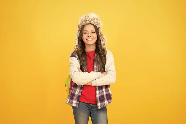 子供の女の子は耳フラップ付きの帽子を着用します。学校での冬のイベント。冬のエンターテイメントと活動。子供気楽な女子高生。冬休み。国際交流・フィールドスクールプログラムへの応募 — ストック写真
