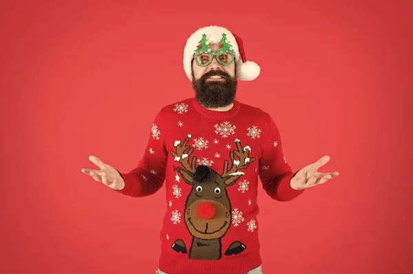 Confused guy. Happy new year celebration. Join holiday celebration. Winter party outfit. Sweater with deer. Hipster bearded man wear winter clothes red background. Christmas celebration ideas — Stock Photo, Image