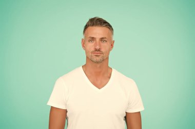 Süper adam. Soyut mavi arka plan. Beyaz orta yaşlı bir adam. Sıradan tarzda yakışıklı bir adam. Moda ve tarz. Sakallı, tıraşsız bir adam. Berber dükkanı. Kuaför salonu.