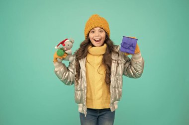 Noel sezonunda alışveriş. Mutlu noeller. Mutlu yıllar. İyi bir hediye için minnettar hissediyorum. Moda ceketli modacı çocuk. Sıcak kışlık giysiler. İnternetten satın alma bonusu. Mutlu küçük kız hediye