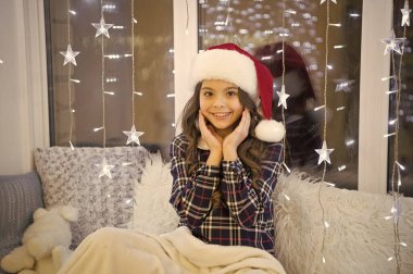 Görünüşüne biraz ışıltı ekle. Mutlu çocuk Noel 'i ve yeni yılı kutluyor. Küçük kız Noel bakışlarıyla gülümsüyor. Küçük bir çocuğun parti görüntüsü. Noel Baba bebek. Şenlikli ve şık görünün.