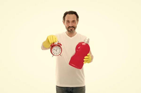 男は家事の仕事の期限を満たす.成熟した髭の男は洗剤と時計を使う。警報を鳴らせ。ずっとね。家庭用化学物質の扱い方です。掃除のコンセプトで時間を節約 — ストック写真