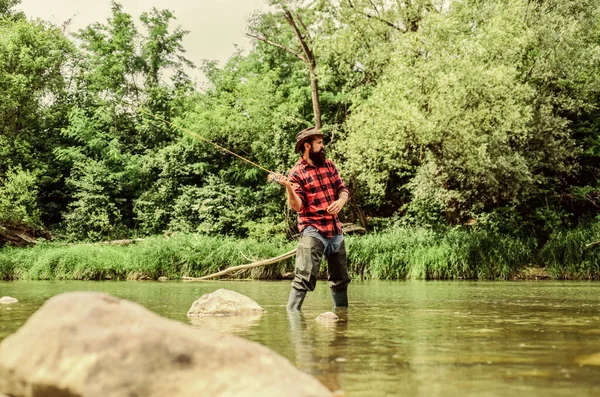 Hombre pescador barbudo. Equipo de pesca del pescador. Actividad deportiva Hobby. piscicultura piscicultura cría de pescado comercialmente. Estanque de laguna de lago de río. Granja de truchas. Pescador solo de pie en el agua del río — Foto de Stock